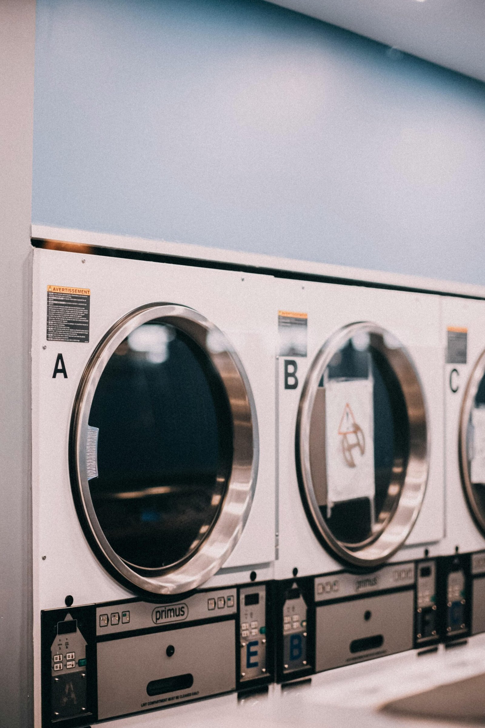Close-up of industrial washing machines in a laundromat setting.