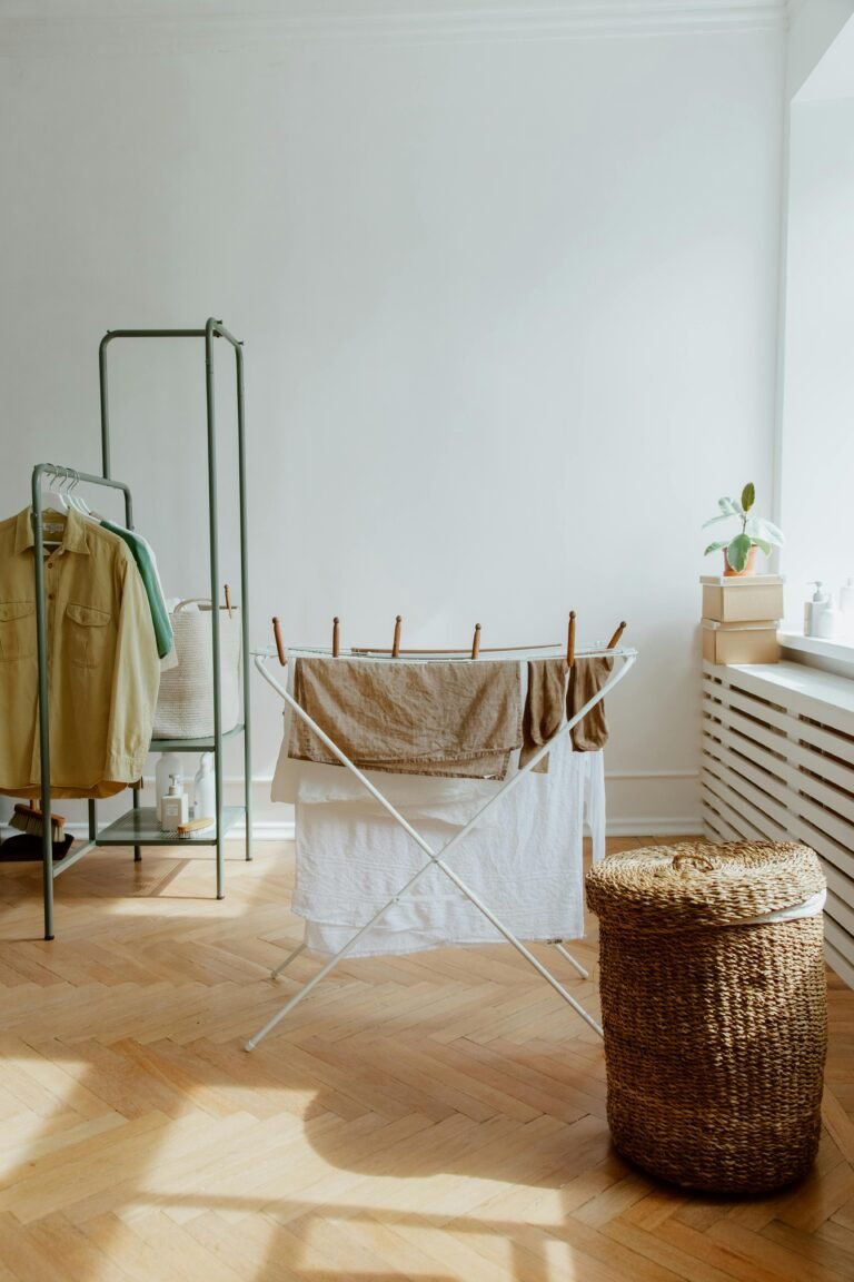 A tidy laundry room with clothes drying and a wicker basket in sunlight.